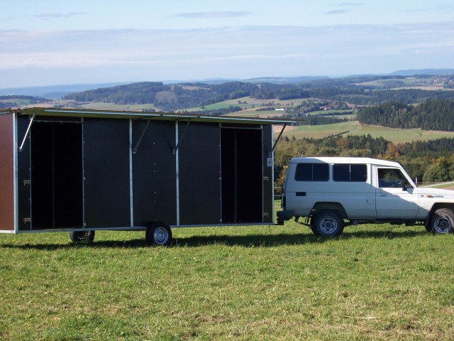 Hier mal ein Bild von der mobilen Weidehütte beim &quot;Umzug&quot; - für den jeweiligen Standort-Wechsel wird sie vorn an der Deichsel mit dem Frontlader angehoben, dann kann eine Steck-Achse angeschraubt werden, auf die von aussen die Räder gesteckt und festgeschraubt werden.