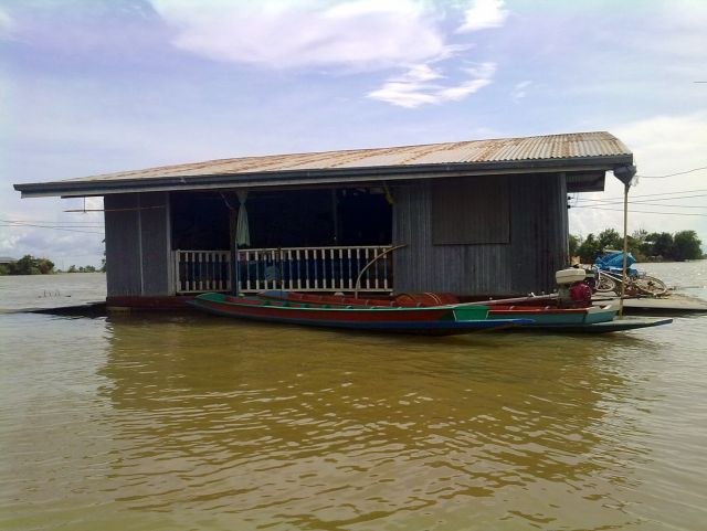 Reisfeld und Farmhaus stroemen mit der Flut davon